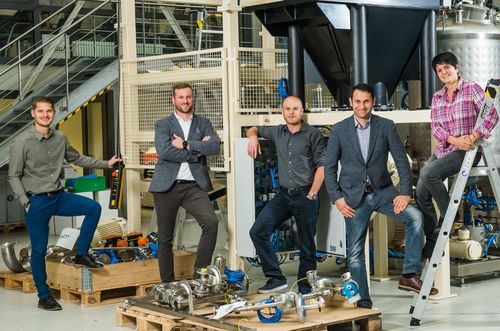 Les employés se tiennent entre les machines et les pièces de la machine
