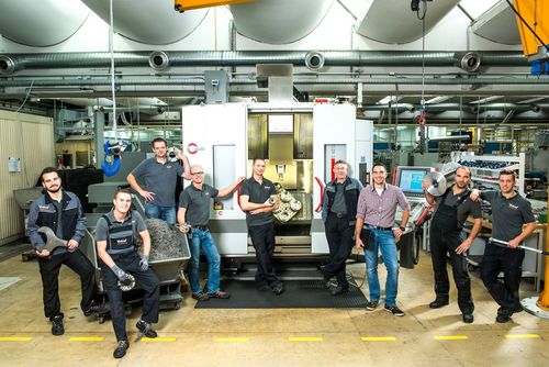 Les employés se tiennent devant les machines et portent les outils de travail